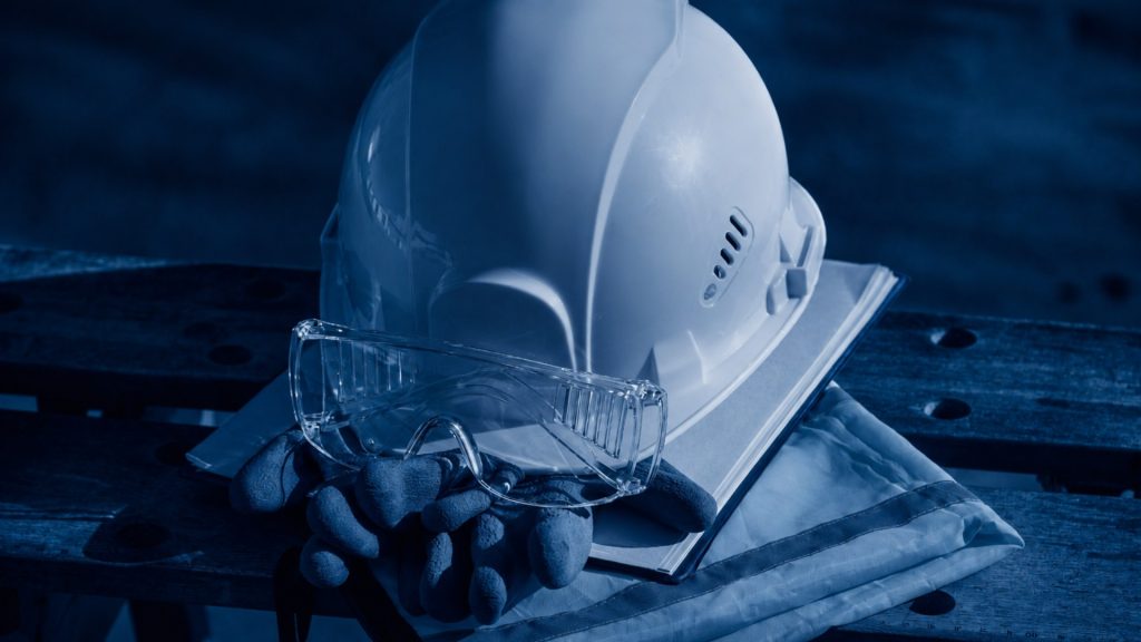 Construction safety helmets and project plans on a desk